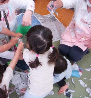 写真：新聞紙をカラーポリ袋に入れる様子