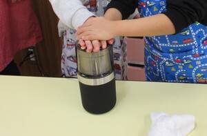 ミルサーで大豆を砕いている