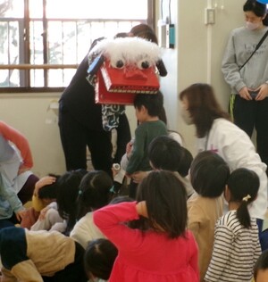 お獅子に頭を噛んでもらっている様子