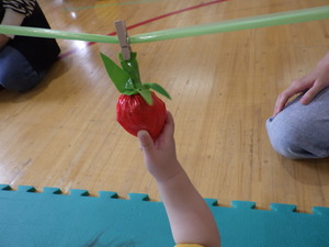 いちごに手を伸ばす子どもの写真