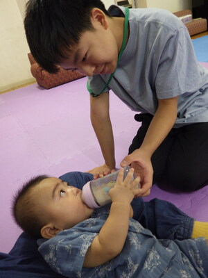 中学生が乳児とふれあっている様子の写真