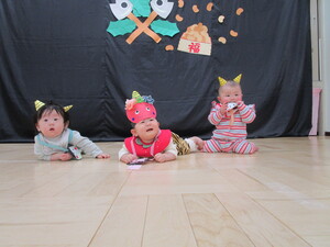 鬼のお面をつけて記念写真をとる赤ちゃん3人