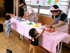 1歳の子どもがアイスクリームに手を伸ばしている写真