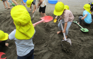 お砂場で砂を掘ってお山を作っている様子