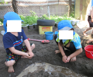 泥を握って泥団子を作る子どもたち