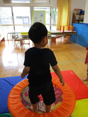 写真:トランポリンをする3歳児