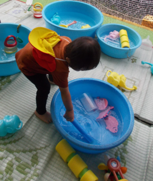 写真：子どもがタライの水をまぜているところ