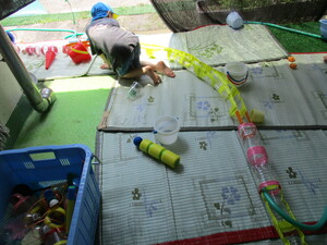 写真:水遊びで水路をつなげる子ども