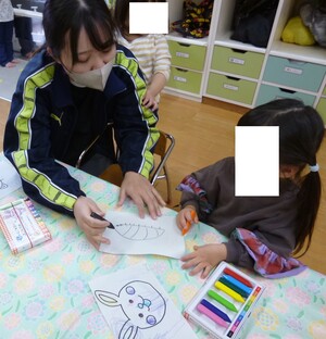 保育士と絵を描いている様子