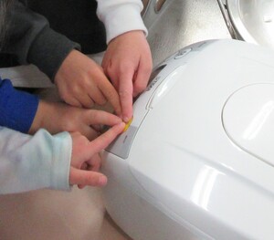 写真：炊飯器のスイッチを押す写真