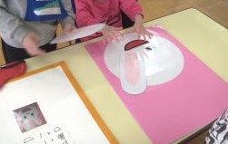 子どもがうさぎの顔の福笑いで遊ぶ様子