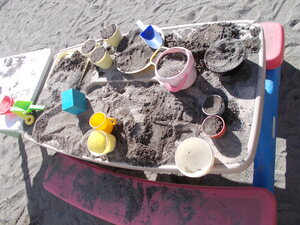 写真：子どもたちが砂場で料理をしているところ